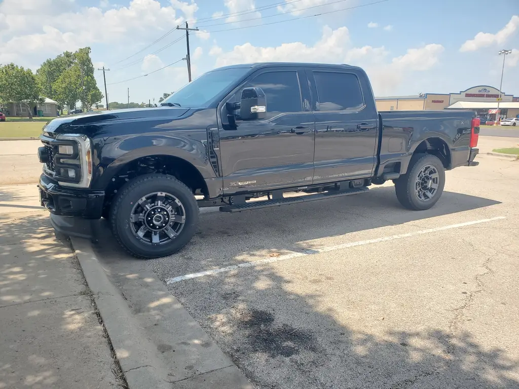 A finished black Ford F-250 Lariat parked at C & C Collision Center's shop on Highway 6