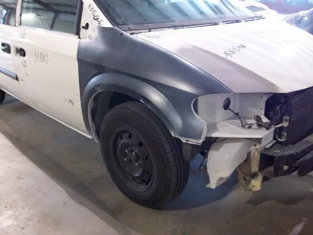 The same Caravan with a replacement front fender in grey primer, masked at the door edge