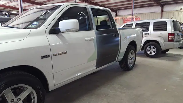 The same Ram with its rear door in grey primer, job number 23 written on the glass